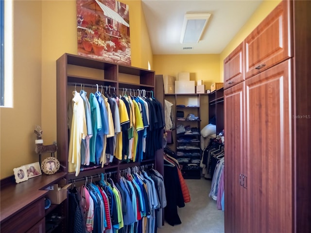 walk in closet featuring light carpet