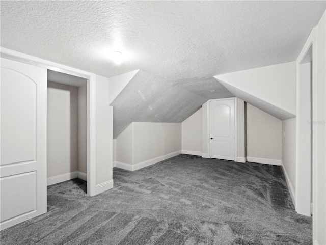 bonus room with dark colored carpet, lofted ceiling, and a textured ceiling