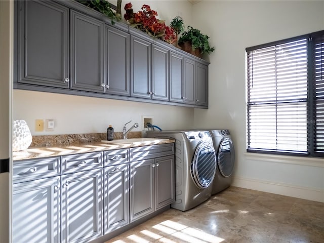 washroom with cabinets, separate washer and dryer, a healthy amount of sunlight, and sink