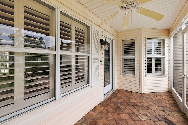 unfurnished sunroom featuring ceiling fan