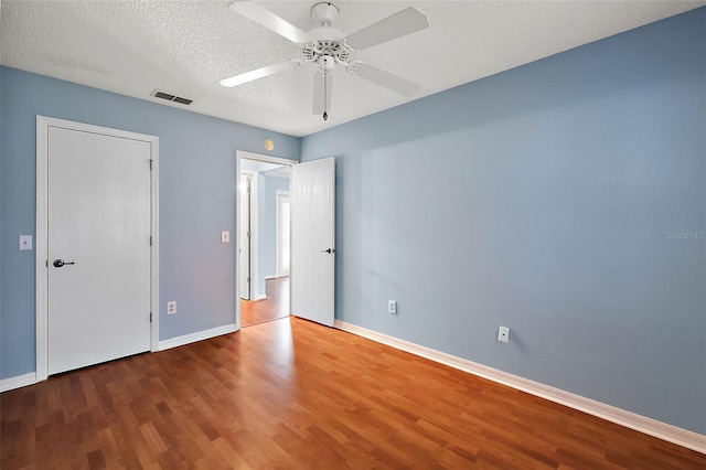 unfurnished room with a textured ceiling, ceiling fan, and wood-type flooring