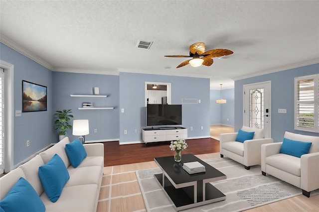 living room with a textured ceiling, ceiling fan, ornamental molding, and hardwood / wood-style flooring