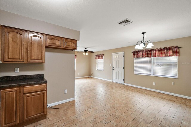 kitchen featuring decorative light fixtures and ceiling fan with notable chandelier