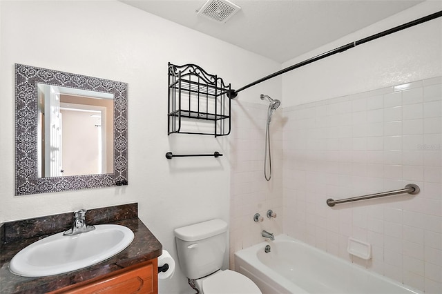 full bathroom featuring tiled shower / bath combo, vanity, and toilet