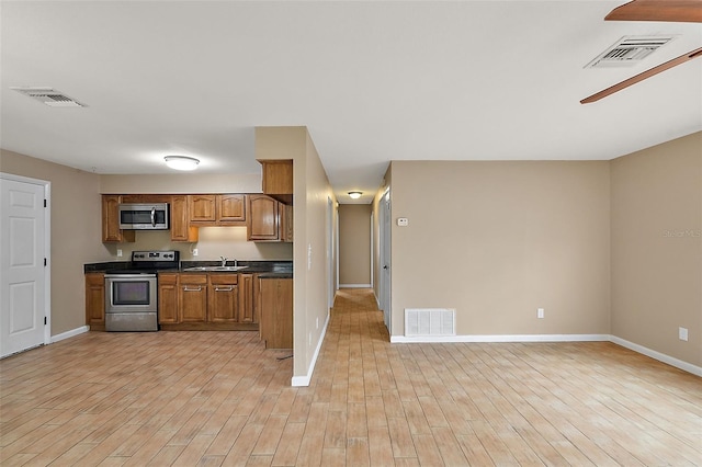 kitchen with stainless steel appliances, light hardwood / wood-style floors, and sink