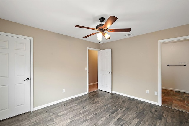 unfurnished bedroom featuring ceiling fan and dark hardwood / wood-style floors