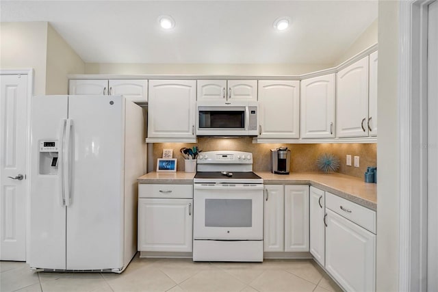 kitchen featuring light countertops, white appliances, and white cabinets