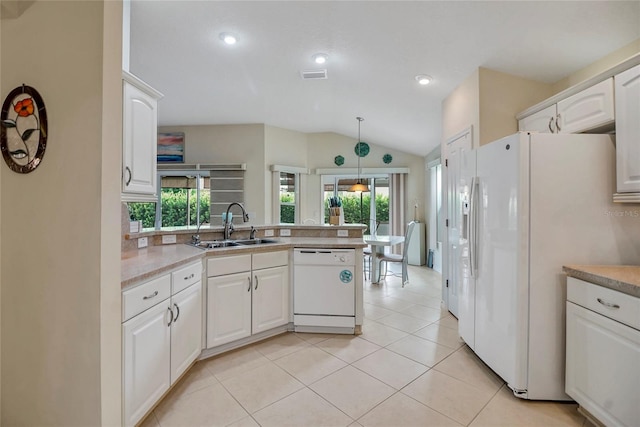 kitchen featuring white appliances, lofted ceiling, white cabinets, sink, and decorative light fixtures