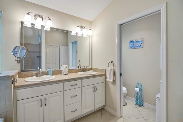 bathroom with tile patterned flooring, vanity, lofted ceiling, and toilet