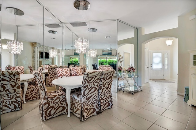 tiled dining space featuring an inviting chandelier