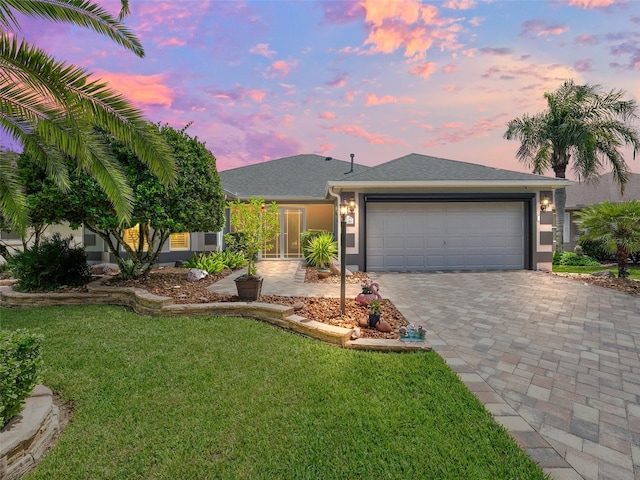 view of front facade featuring a garage and a yard