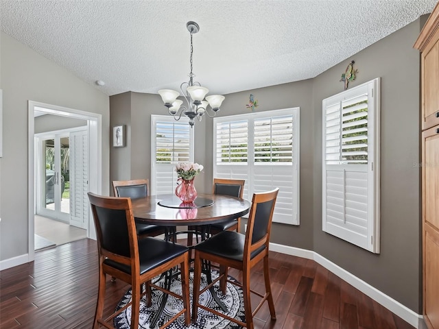 dining room with a textured ceiling, vaulted ceiling, dark hardwood / wood-style floors, and a notable chandelier