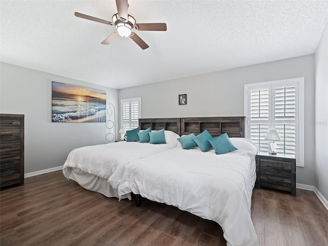 bedroom featuring multiple windows, dark hardwood / wood-style flooring, ceiling fan, and a textured ceiling