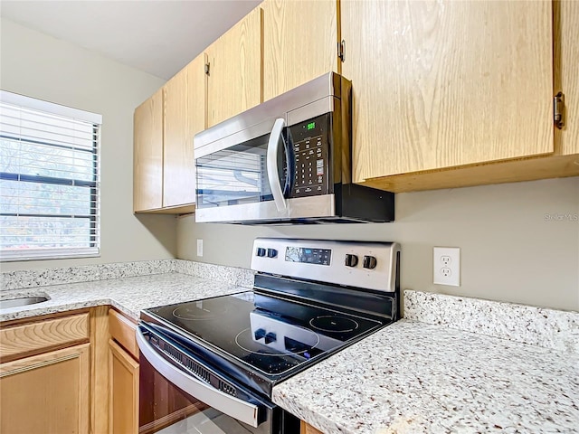 kitchen featuring stainless steel appliances and light brown cabinets