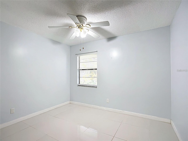 tiled empty room with ceiling fan and a textured ceiling