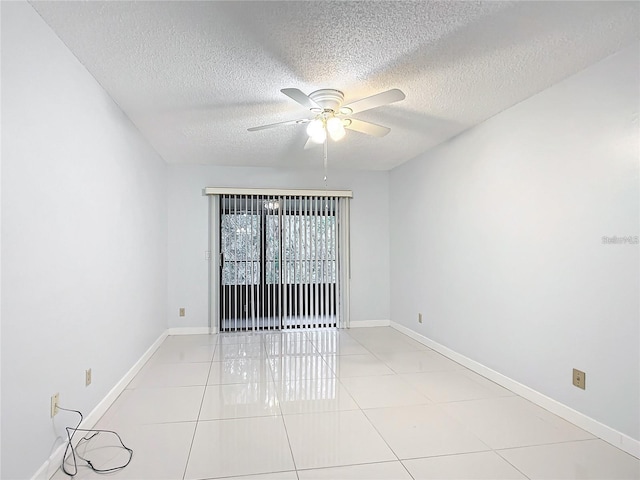 tiled empty room with ceiling fan and a textured ceiling