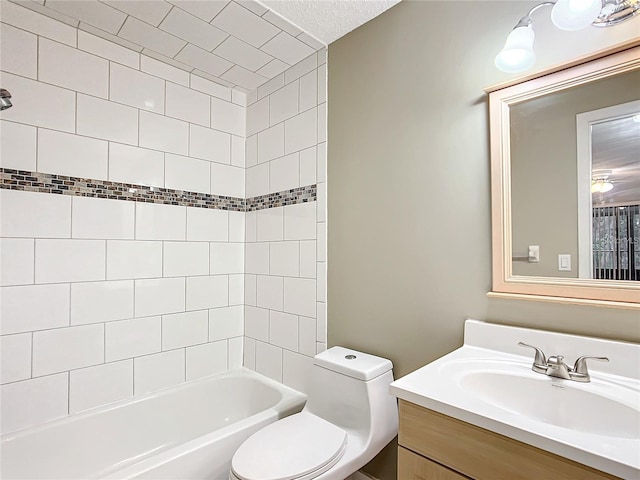 full bathroom featuring a textured ceiling, toilet, tiled shower / bath combo, and vanity