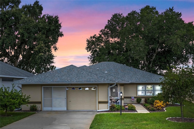 view of front of home with a yard and a garage