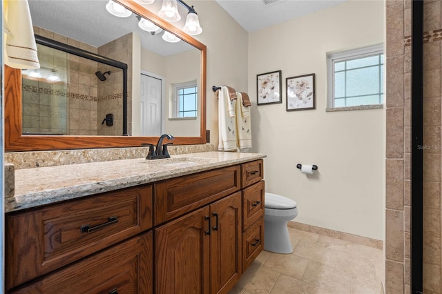 bathroom featuring a textured ceiling, vanity, toilet, and an enclosed shower