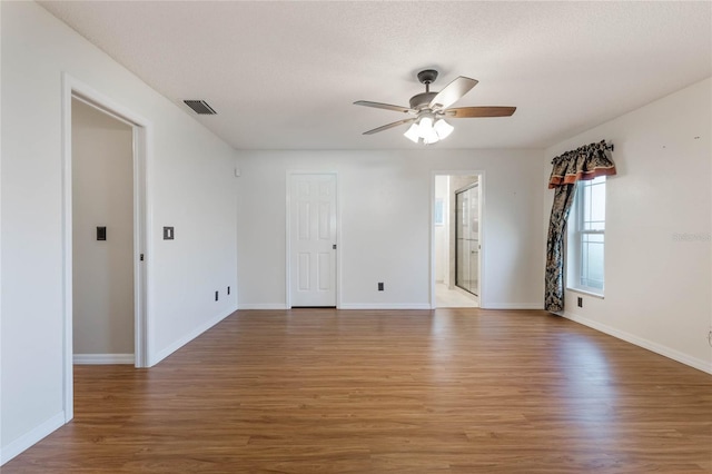 spare room with ceiling fan, wood-type flooring, and a textured ceiling