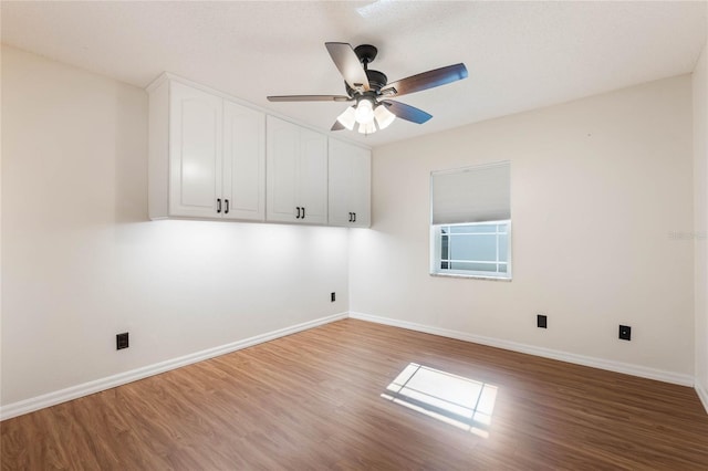 empty room with ceiling fan and hardwood / wood-style floors