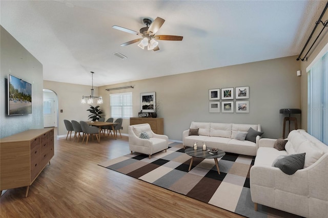 living room with hardwood / wood-style floors and ceiling fan with notable chandelier