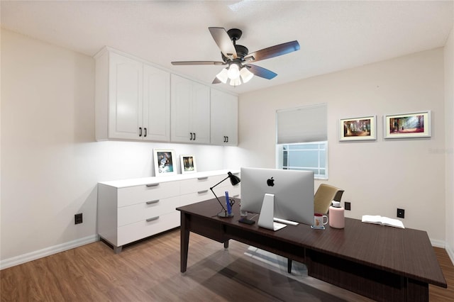 office with light hardwood / wood-style flooring and ceiling fan