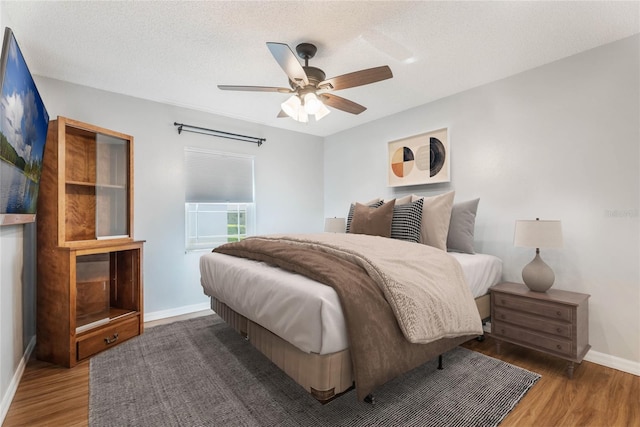 bedroom featuring wood-type flooring, a textured ceiling, and ceiling fan