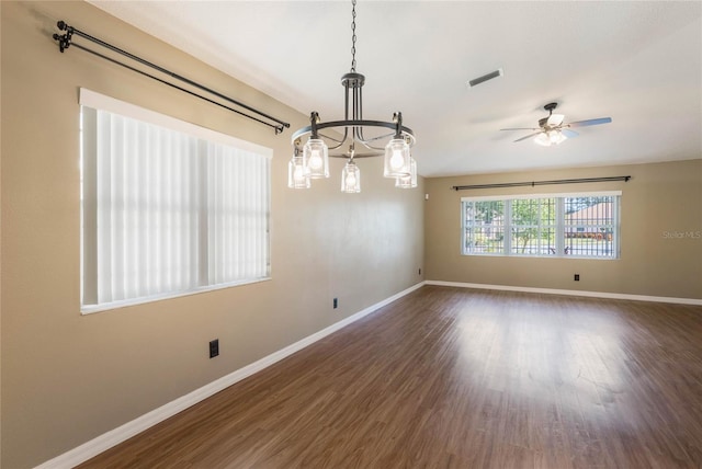 spare room featuring dark hardwood / wood-style flooring and ceiling fan with notable chandelier