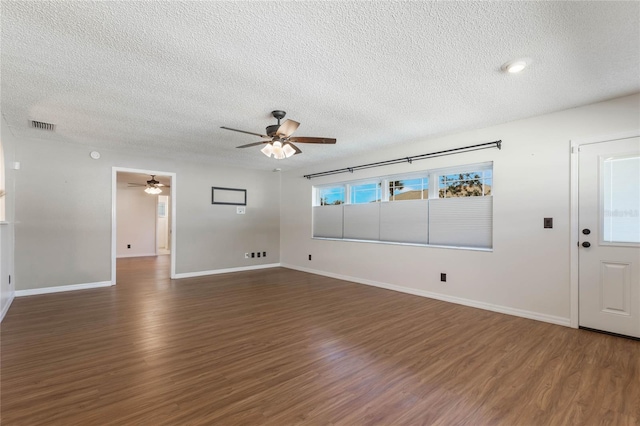 interior space with a textured ceiling, dark hardwood / wood-style flooring, and ceiling fan