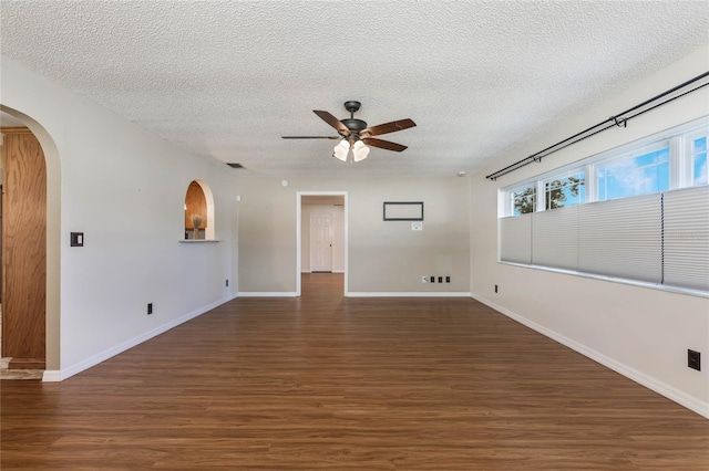 empty room featuring a textured ceiling, dark hardwood / wood-style flooring, and ceiling fan