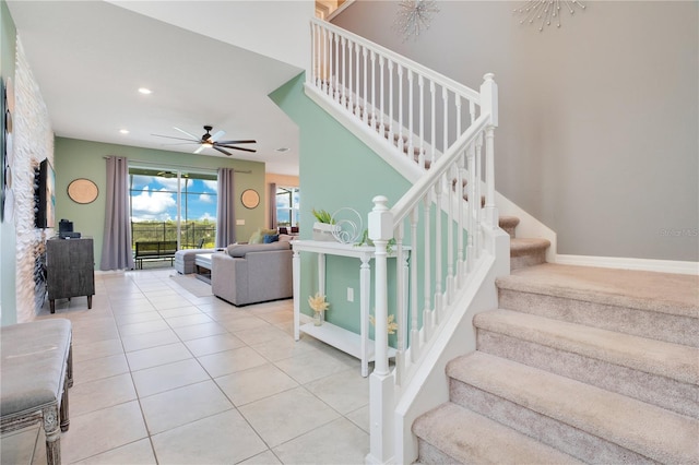 staircase with ceiling fan and tile patterned floors