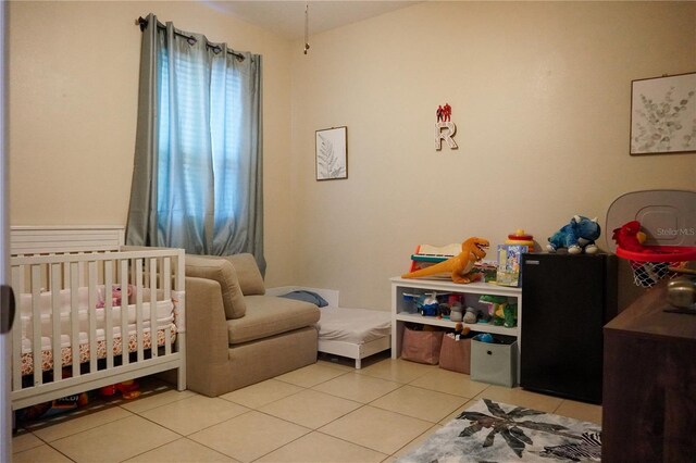 bedroom featuring light tile patterned flooring and a crib