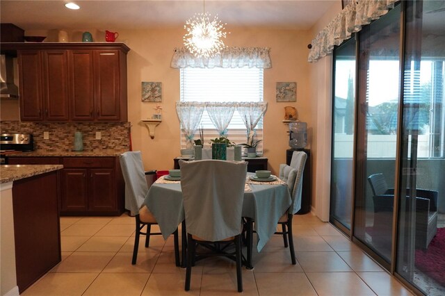 dining area featuring a chandelier, light tile patterned flooring, and a healthy amount of sunlight