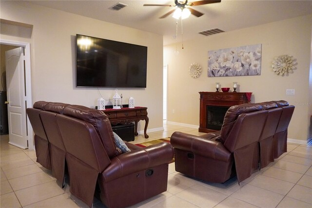 living room with ceiling fan, light tile patterned floors, a fireplace, and visible vents