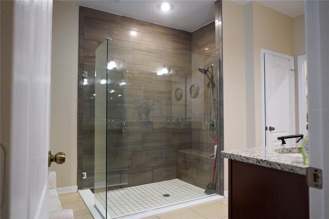 full bath featuring a shower stall, vanity, and tile patterned floors