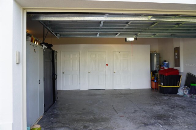 garage featuring a garage door opener, electric panel, and water heater