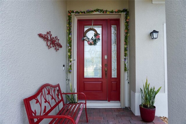 entrance to property featuring stucco siding