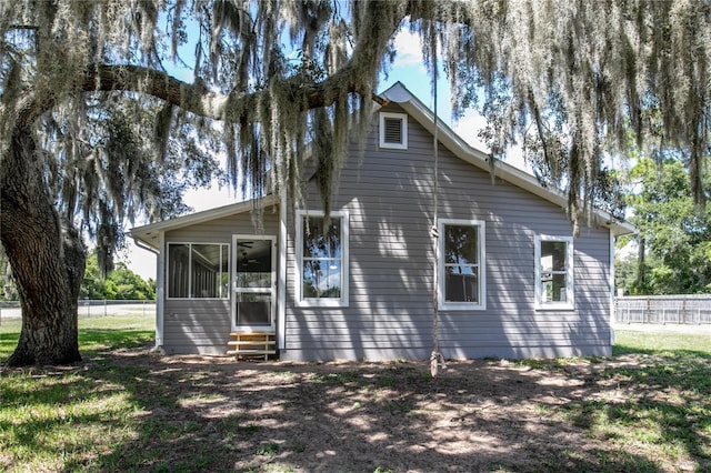 rear view of house with a sunroom and a lawn