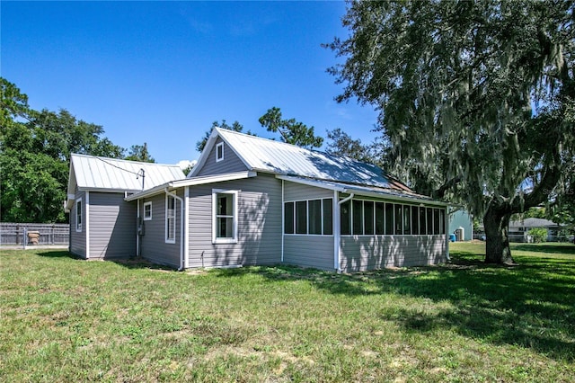19402 E 5th St, Umatilla, FL 32784 - view of home's exterior featuring a lawn, a sunroom, and metal roof