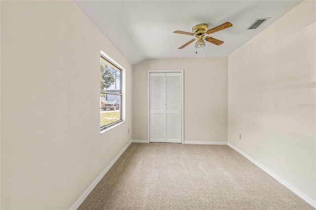 19402 E 5th St, Umatilla, FL 32784 - unfurnished bedroom featuring light carpet, a closet, baseboards, lofted ceiling, and a ceiling fan