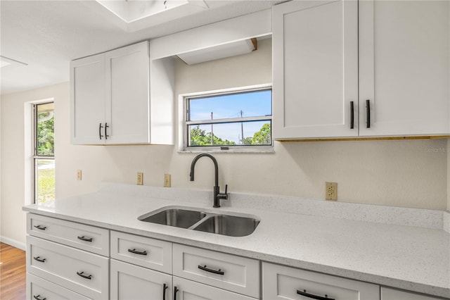 19402 E 5th St, Umatilla, FL 32784 - kitchen featuring a sink, white cabinets, wood finished floors, and light stone counters