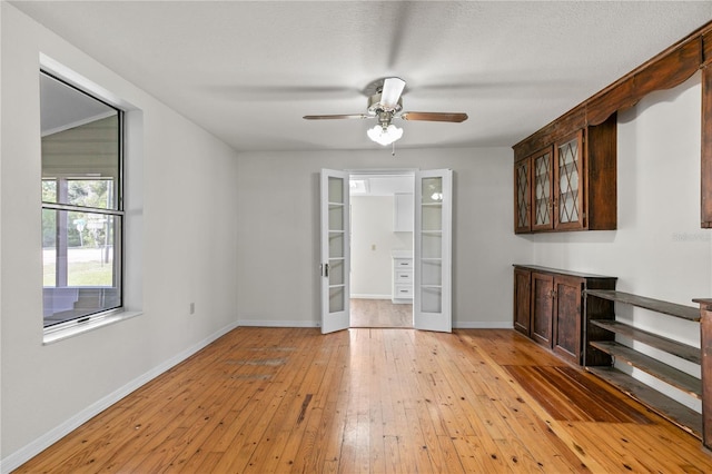 19402 E 5th St, Umatilla, FL 32784 - unfurnished living room featuring french doors, light wood finished floors, a ceiling fan, and baseboards