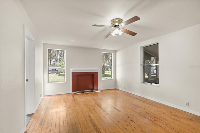 19402 E 5th St, Umatilla, FL 32784 - unfurnished living room featuring ceiling fan, light wood finished floors, and baseboards