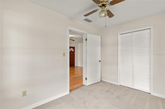 19402 E 5th St, Umatilla, FL 32784 - unfurnished bedroom featuring light colored carpet, baseboards, a closet, and a ceiling fan