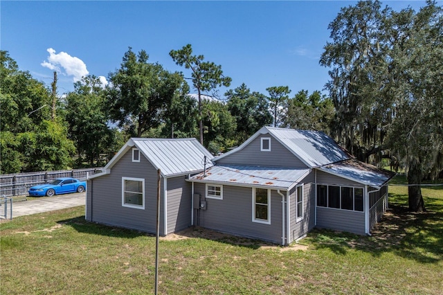 19402 E 5th St, Umatilla, FL 32784 - rear view of house with metal roof and view of scattered trees