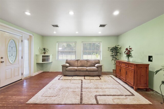 living room with dark wood-type flooring, recessed lighting, and visible vents