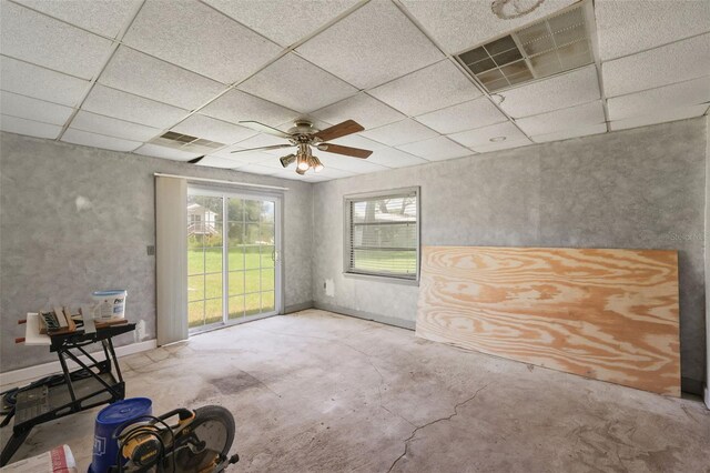 spare room with baseboards, a paneled ceiling, visible vents, and unfinished concrete floors