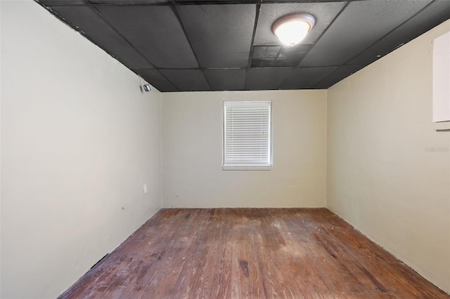 spare room with hardwood / wood-style floors and a drop ceiling