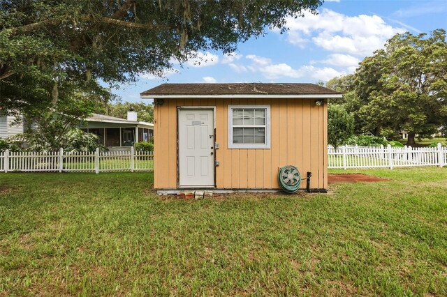 view of shed featuring fence and a sunroom